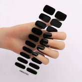 Gel nail stickers in black design on hand, semi-curing heating lamp hardening.