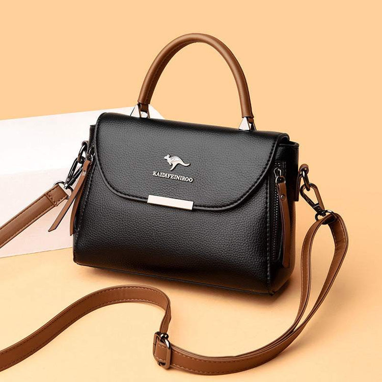 Fashionable stylish women's crossbody shoulder bag in black leather with brown strap, featuring elegant design and functional compartments.