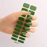 Gel nail stickers in green shade displayed on a hand.