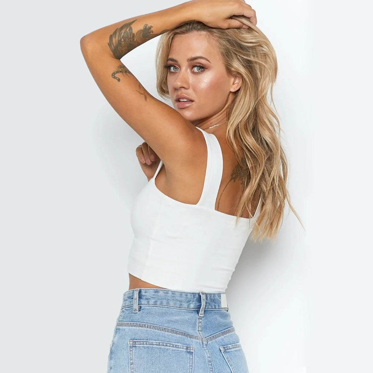 Fashionable women's white sleeveless crop top tank paired with denim jeans.