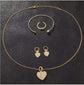 Gold diamond bracelet, ring, earrings, and necklace set with heart design.