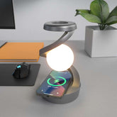 Rotating hanging mobile phone wireless charging lamp on a desk.