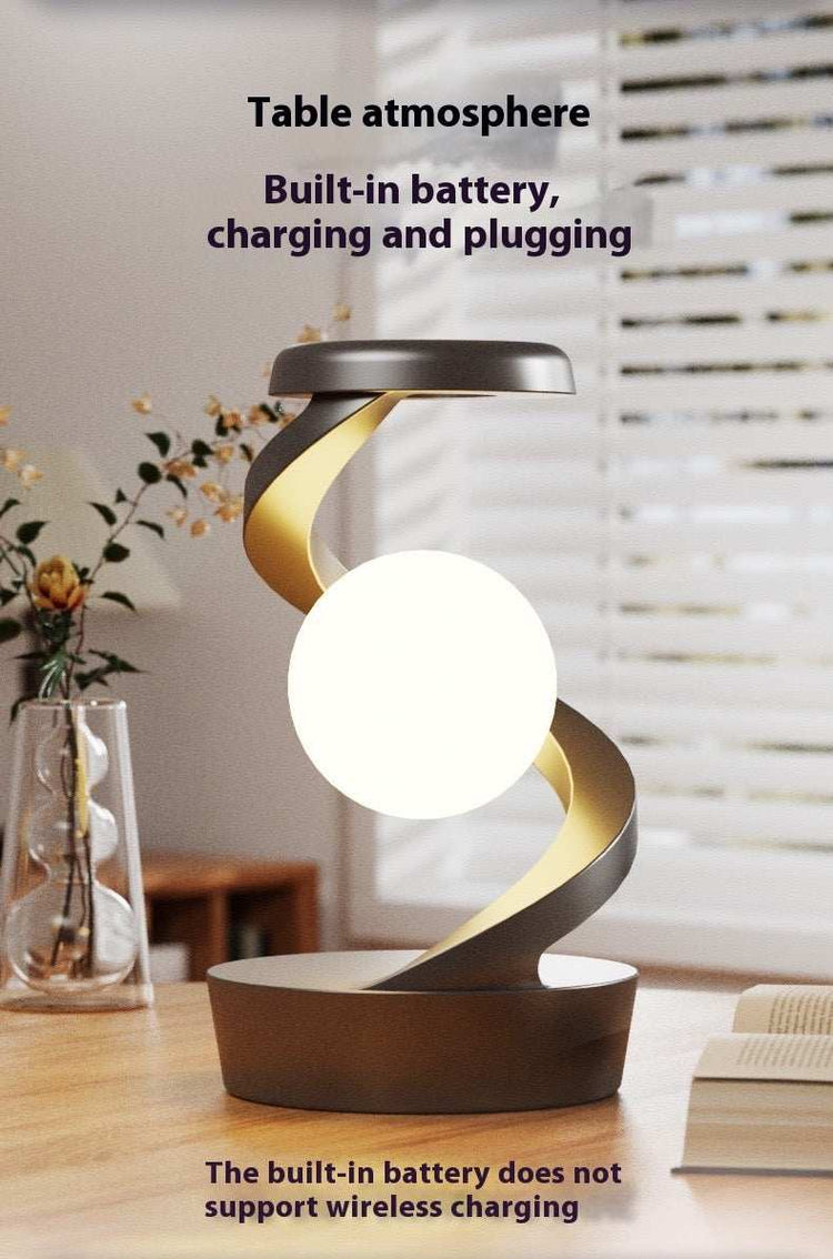 Rotating hanging mobile phone wireless charging lamp on wooden table.