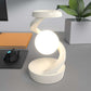 Rotating hanging mobile phone wireless charging lamp on desk.