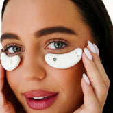 Woman applying soothing eye capsules for relaxation and revitalization on tired eyes.