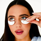 Woman applying soothing eye capsules for revitalization and relaxation.