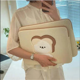 Women holding a cute laptop sleeve case with cartoon design, suitable for various laptop sizes.