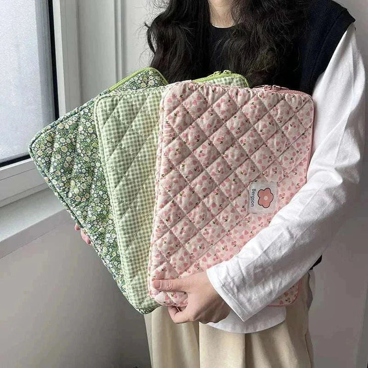 Women holding cute quilted laptop sleeve cases in floral patterns.