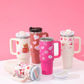 Colorful thermos cups with handles and straws, featuring festive designs.