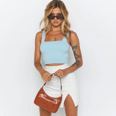 Fashionable women in light blue sleeveless crop top with accessories.