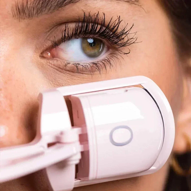 woman using heated eyelash curler for perfectly curled lashes