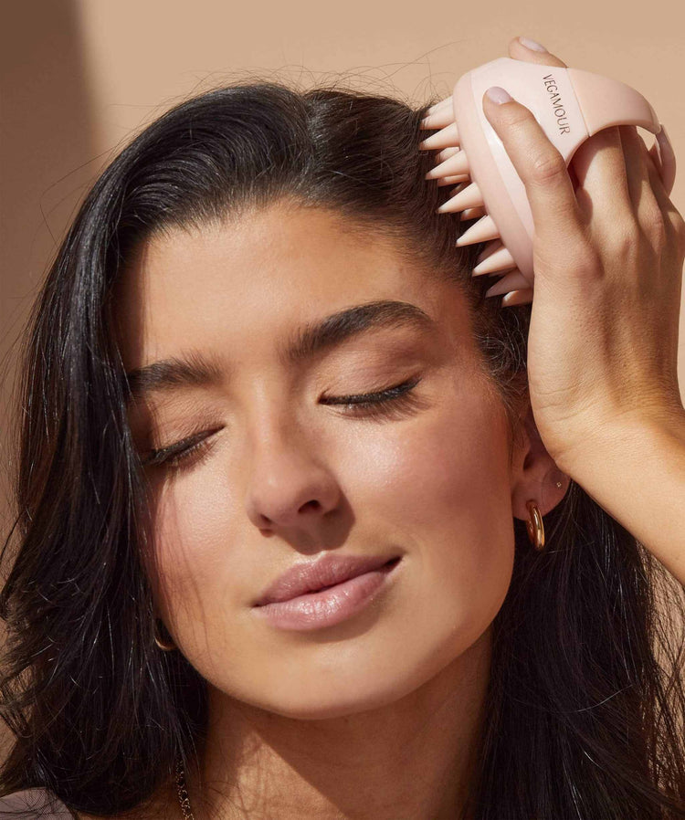 Woman using a Revitalizing Scalp Massager for relaxation and hair health enhancement.